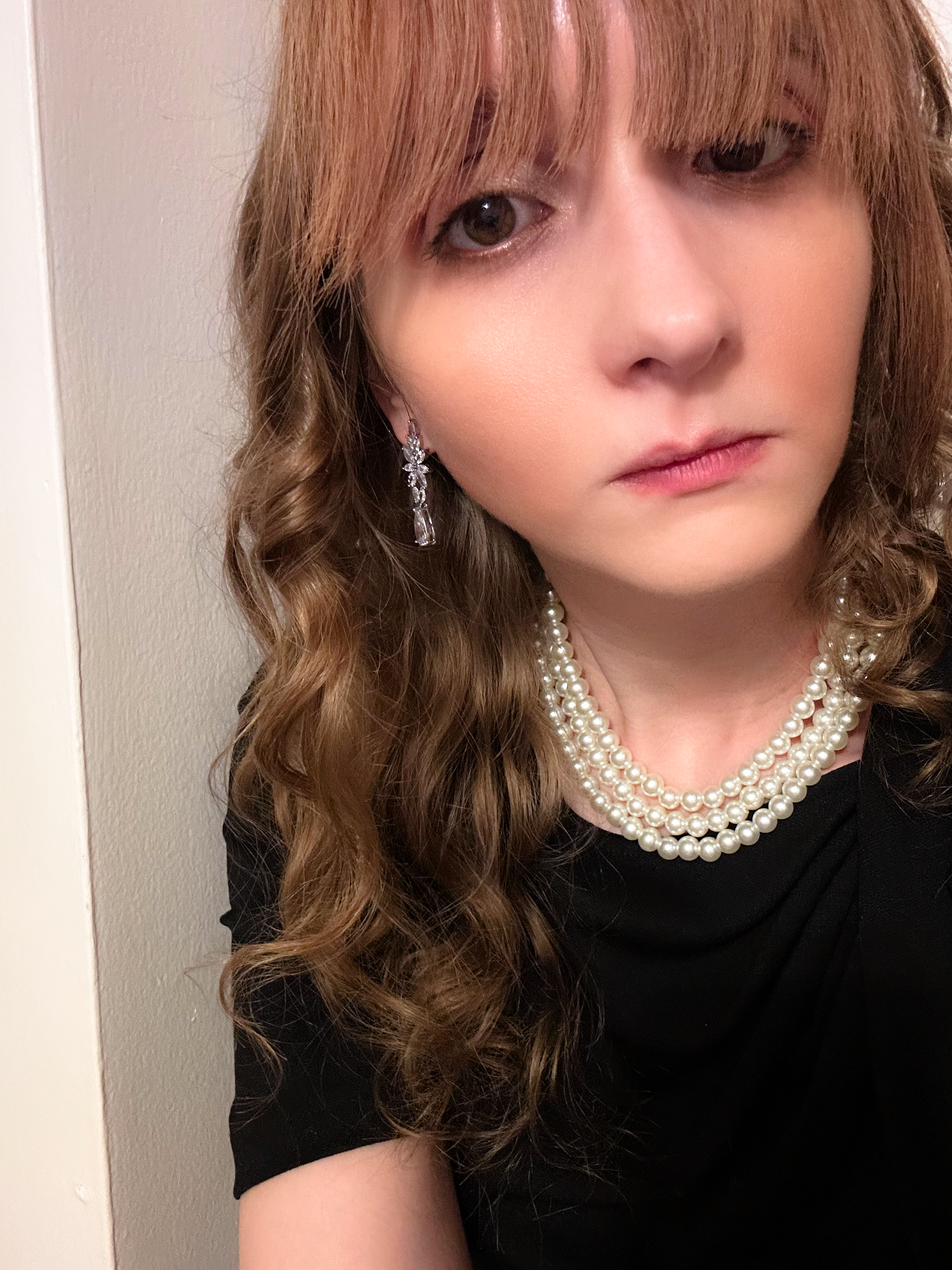 Katherine Moon, the owner of Stridefully, wearing a black dress with pearls.